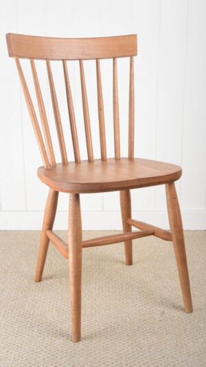 A wooden chair with a long back and curved seat.