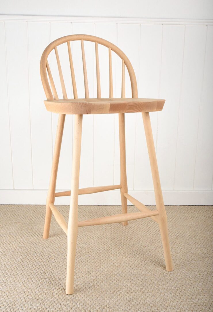 A wooden chair with a bent back and foot rest.
