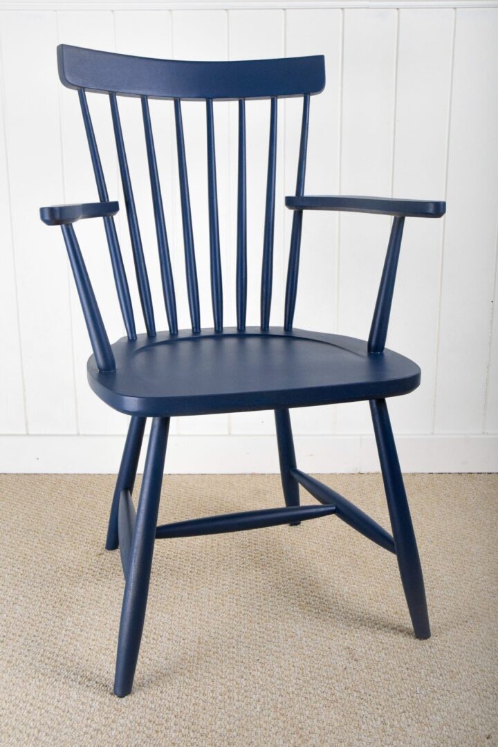 A blue chair sitting on the floor in front of a white wall.