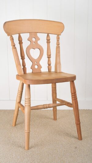 A wooden chair with a heart shaped back.
