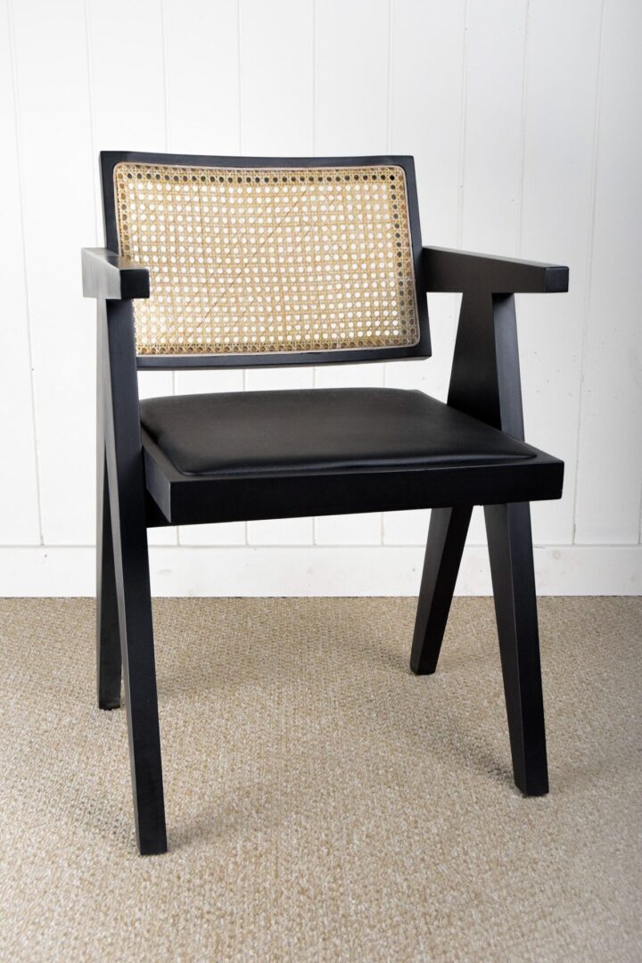 A black chair with a cane back and seat.