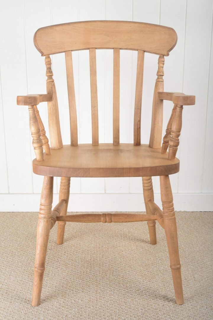 A wooden chair with arms and back rests.