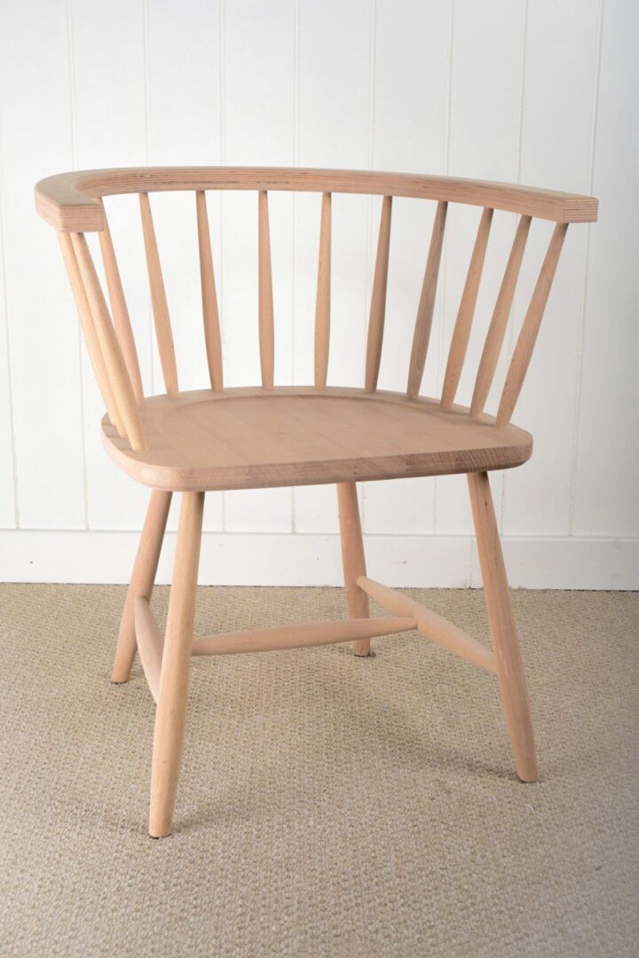 A wooden chair sitting on the floor in front of a wall.