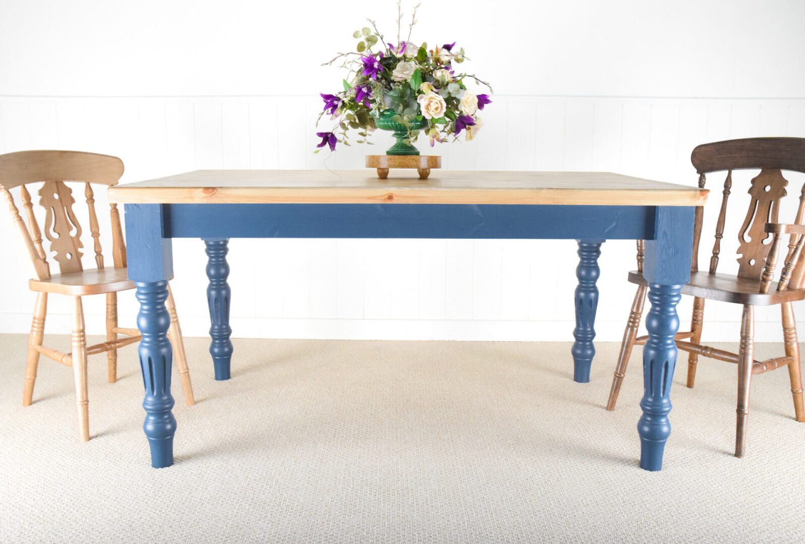 A blue table with flowers in the middle of it
