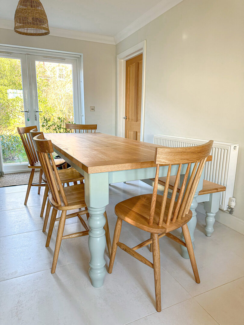 A dining room table with six chairs and a bench.