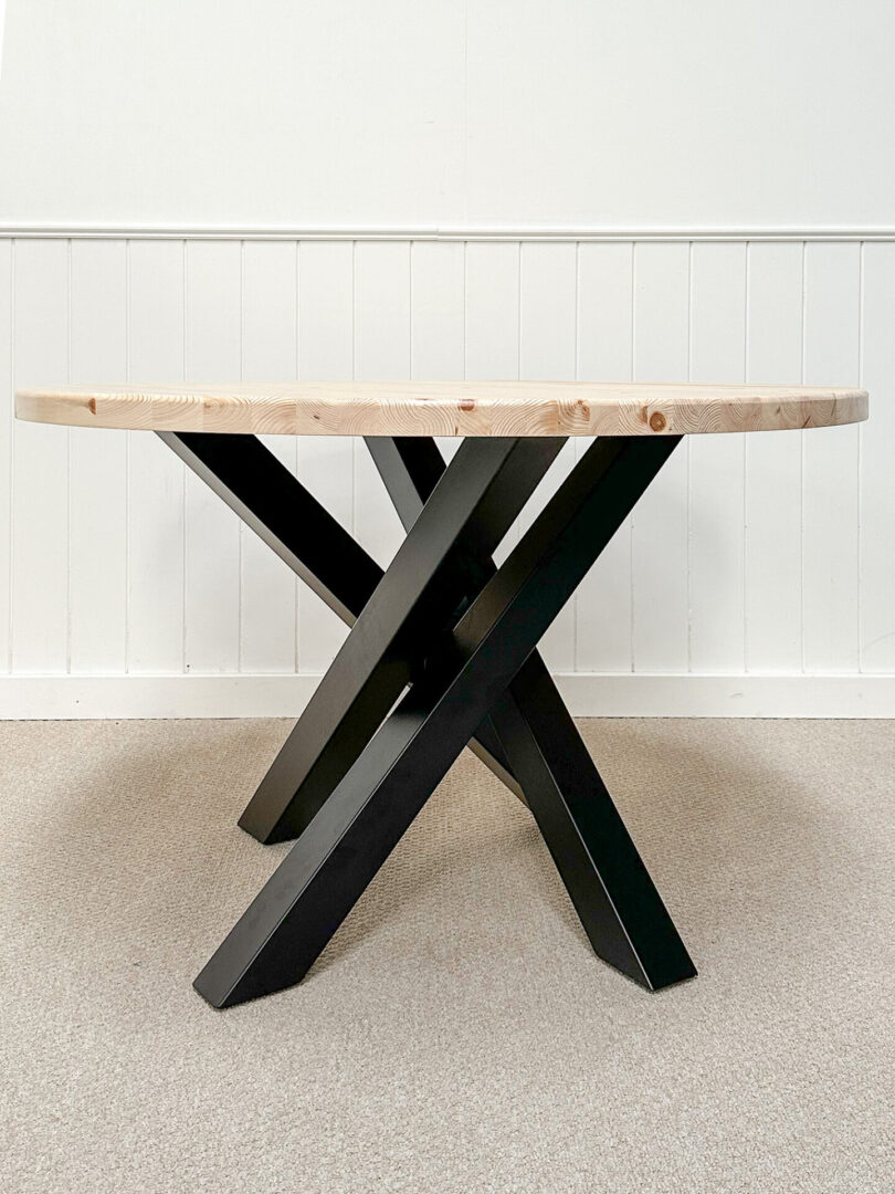 A table with black legs and wooden top.