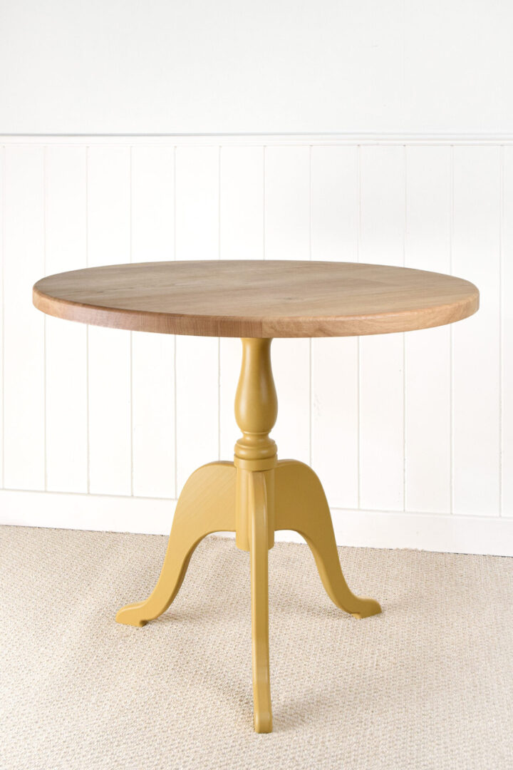 A table with a yellow base and wooden top.