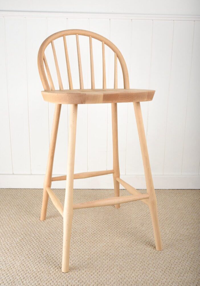 A wooden chair with a bent back and foot rest.